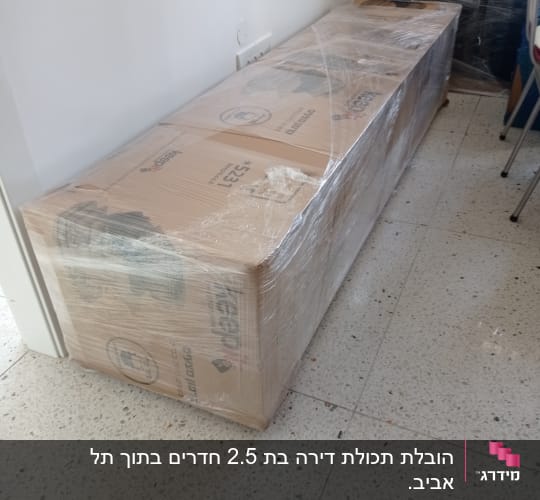 קופסה גדולה עטופה בניילון שקוף על הרצפה